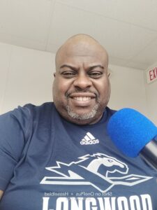 Shawn Mears with a microphone announcing a game.