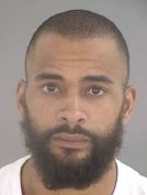 Image shows a Black male, with a buzzed head and black beard.
