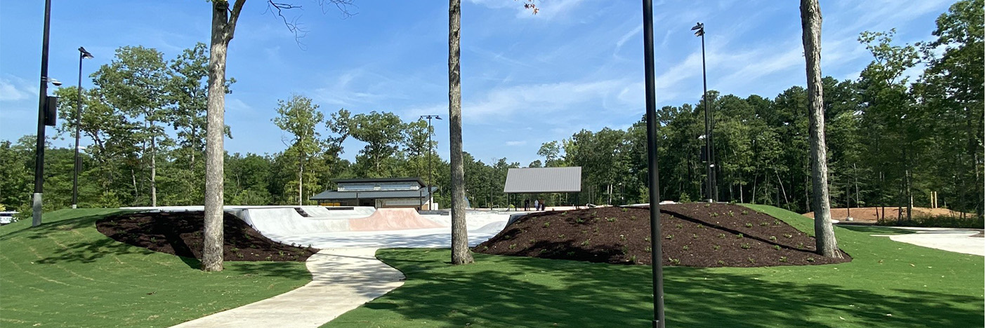 Entrance to a skatepark, concrete area with slopes and areas to perform tricks.