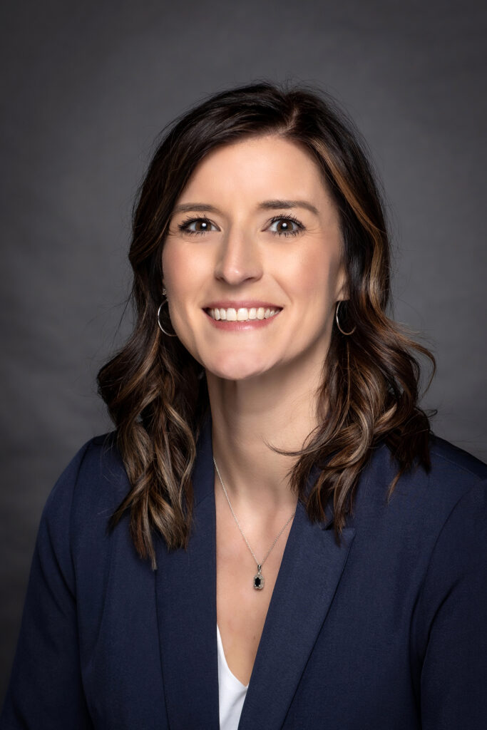 A woman smiles in a professional portrait.