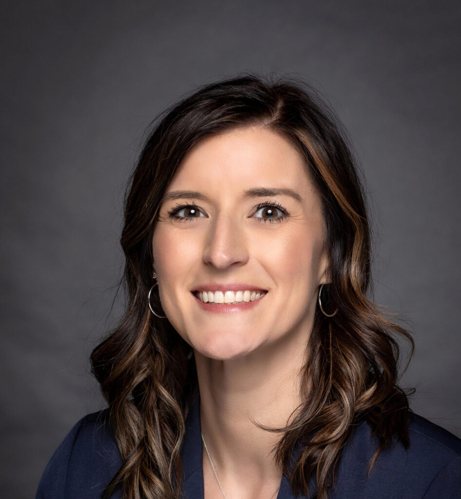A woman smiles in a professional portrait.
