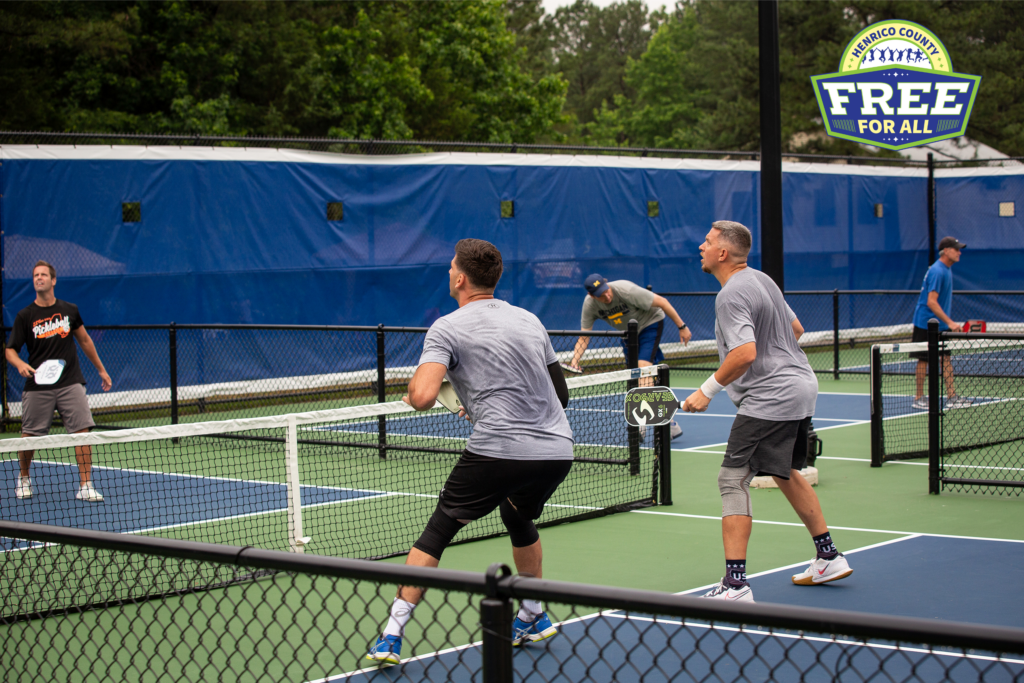 A photo shows a group of people playing pickleball outside.