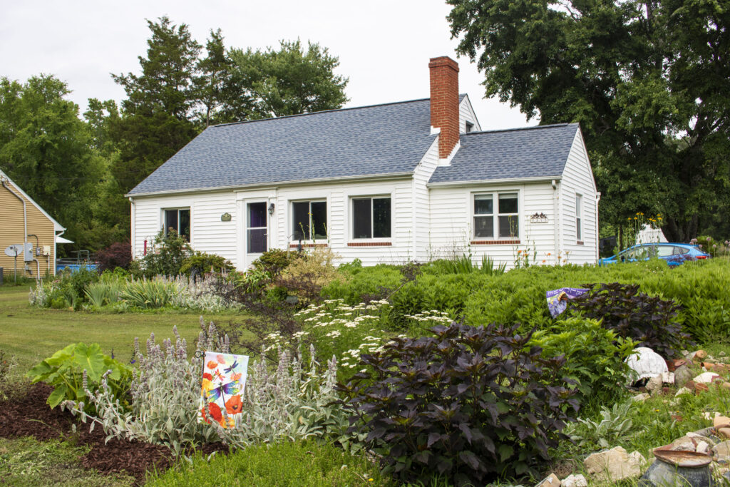 photo of a house with a very large plant bed lining the front of the house and perimeter of the yard