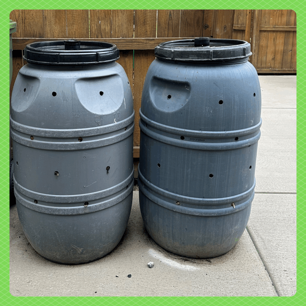 Photo of two upright plastic barrels with lids and holes drilled into the sides.