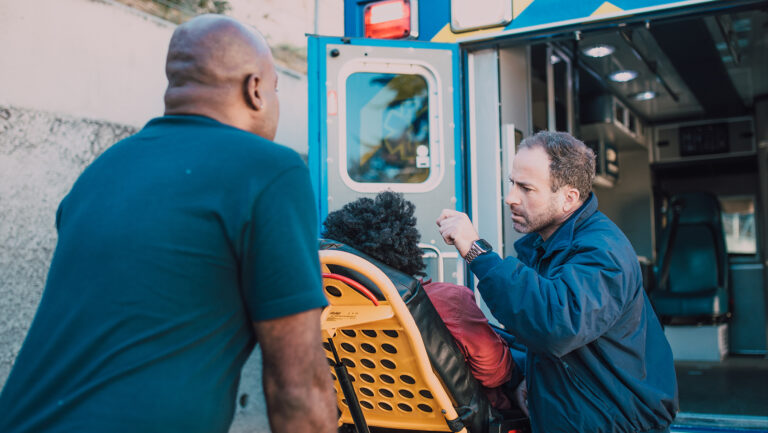 A photo of emergency responders with a patient on a stretcher.