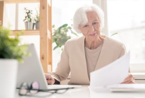 woman with gray hair working at a laptop