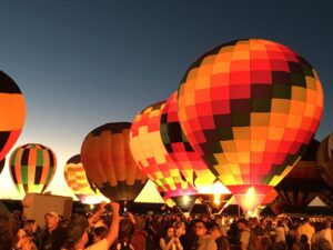 Hot air balloons lit up in the night sky 