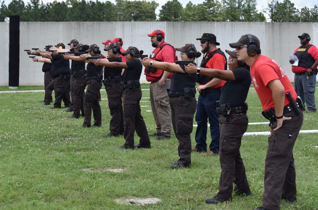 Group of men and women pointing gun