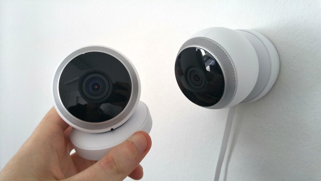 Person holding a camera that's part of a home security system.