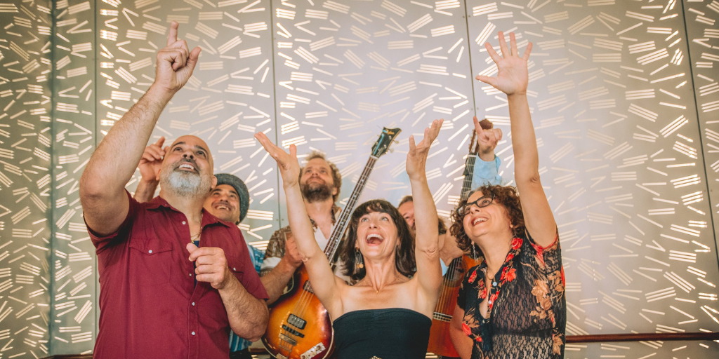 People raising their hands and guitar to the sky