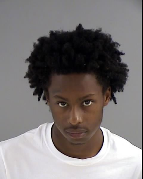 Image shows a Black male with tight curly hair