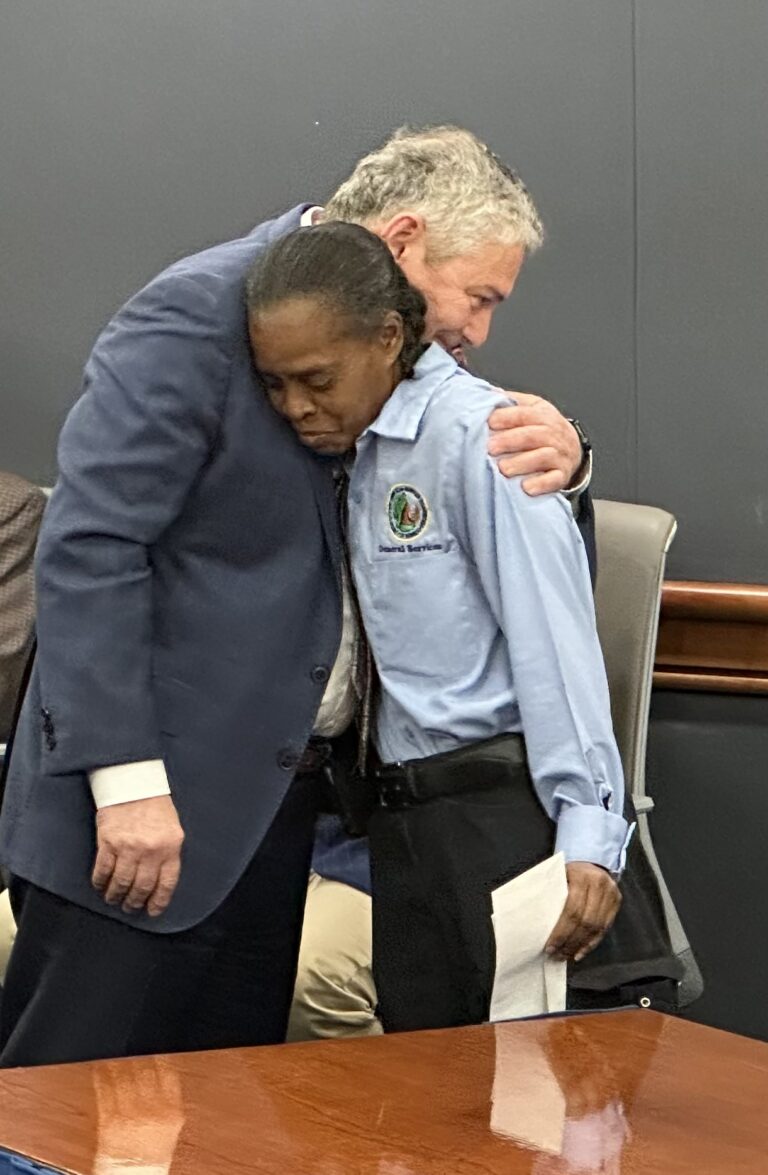 Julie Smith appears emotional as John Vithoulkas embraces her after handing her her spot bonus.