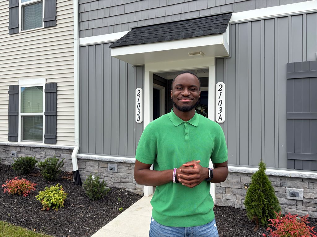 Image shows Xavier Nora infront of his home.