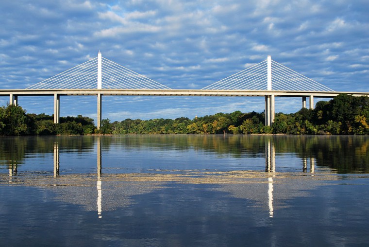 An image of the Varina-Enon Bridge during the day reflecting in the water below.